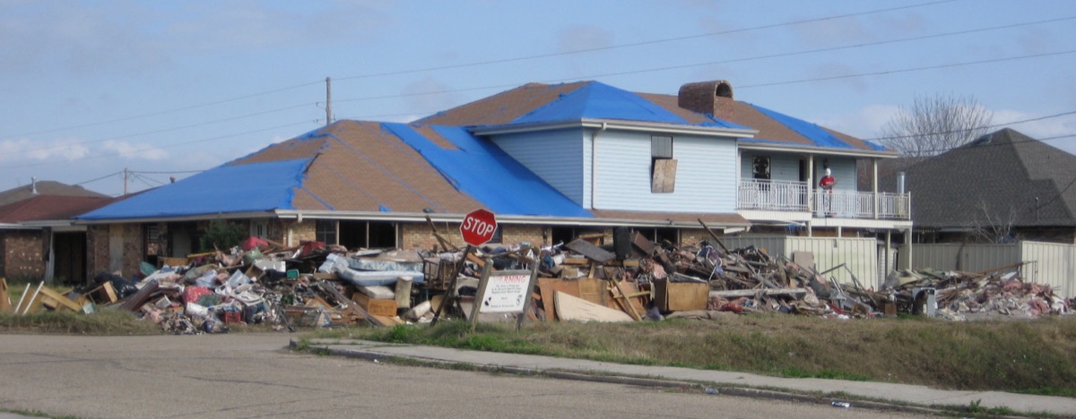 Floodwater debris and ruined possessions being removed from a Chalmette, Louisiana home during Katrina cleanup — discard porous items soaked in Category 3 floodwater