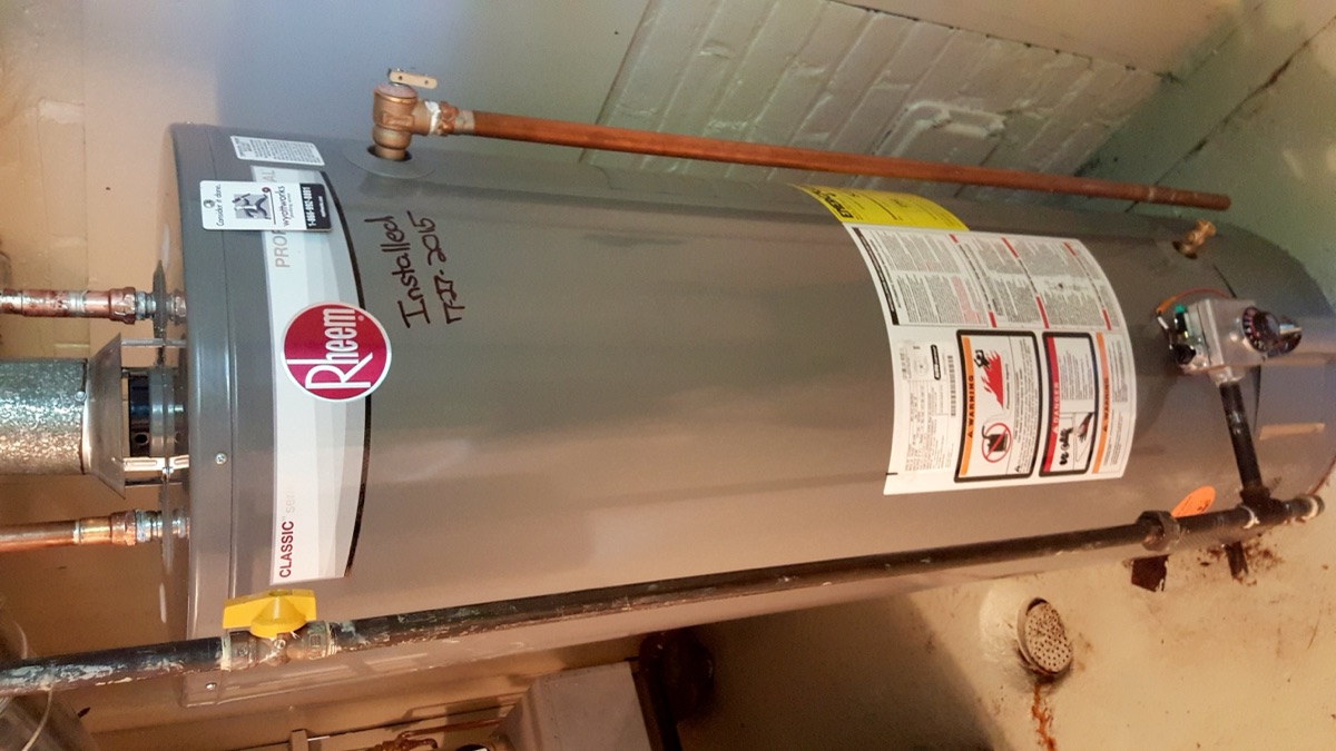A newly installed residential gas water heater tank replacing a failed unit