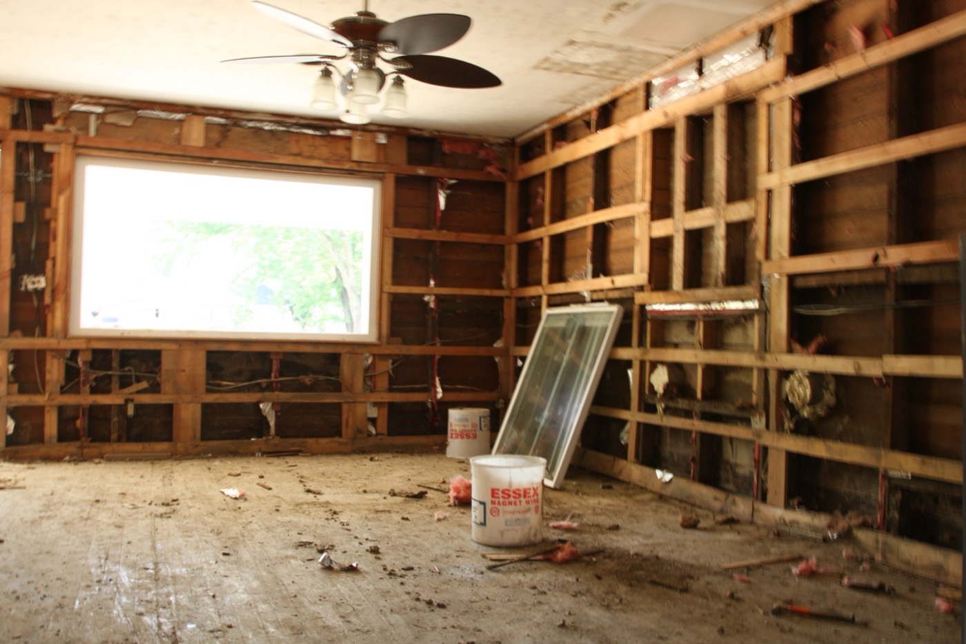 Damaged interior of a flooded home with insulation stripped from the walls during flood recovery